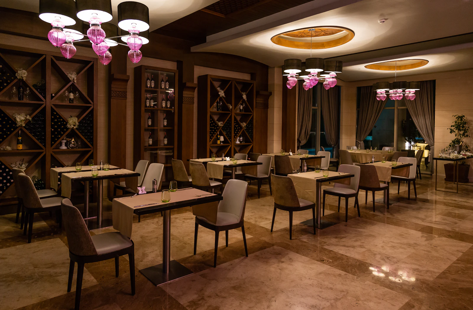 The warmly lit dining room with wooden tables